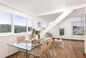 a dining room with a glass table and chairs at Trethoway in Port Isaac