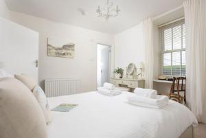 a white bedroom with two white pillows on a bed at Trethoway in Port Isaac