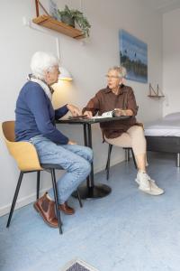 two older women sitting at a table in a room at Danhostel Rønde in Rønde