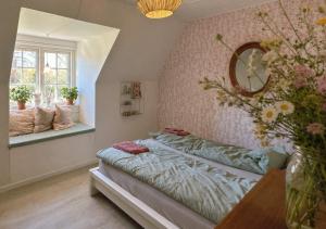 ein Schlafzimmer mit einem Bett und einer Blumenvase in der Unterkunft SleepOrup in Faxe