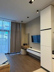 a bedroom with a tv on the wall and a bed at Sea Breeze Lighthouse 3 Studio ML in Nardaran