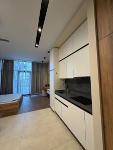 a kitchen with white cabinets and a bed in a room at Sea Breeze Lighthouse 3 Studio ML in Nardaran +16 photos
