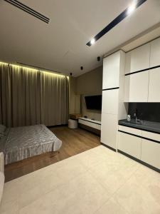 a bedroom with a bed and a television in it at Sea Breeze Lighthouse 3 Studio ML in Nardaran