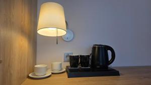 a coffee maker and two cups on a table at Penzión Jánsky kaštieľ Bohumírovský in Liptovský Ján