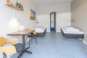 a room with two beds and a table and chairs at Danhostel Rønde in Rønde