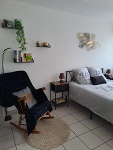 a bedroom with a bed and a chair next to a bed at Meublé 3 étoiles en centre-ville in Niederbronn-les-Bains +36 photos