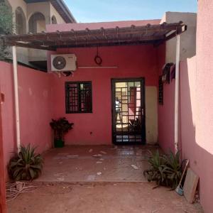 an outside view of a pink house with a door at Unique in Ouagadougou