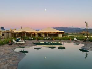 a swimming pool in a resort with mountains in the background at Dar Diyafa Marrakech in Maout
