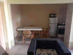 a small kitchen with a table and a refrigerator at Unique in Ouagadougou