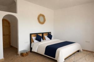 a bedroom with a large bed with blue and white pillows at Dar Diyafa Marrakech in Maout +34 photos