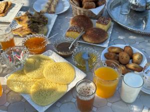 a table topped with plates of food and drinks at Dar Diyafa Marrakech in Maout