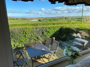 a patio with a table and chairs and a view of a field at Craigmore Caravan in Coleraine