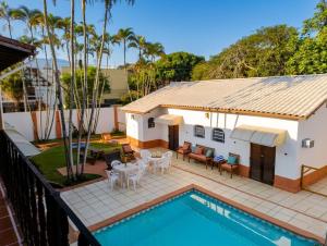 a house with a swimming pool and a patio with tables and chairs at Casa Aconchegante para até 6 Pessoas a 100m do Mar in São Sebastião
