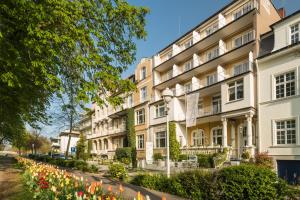 an apartment building with flowers in front of it at Privat-Hotel Villa Aurora in Bad Neuenahr-Ahrweiler