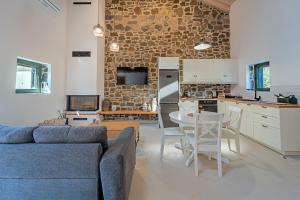 a living room with a couch and a table and a kitchen at Twin Olive Villas in RhodesRhodes