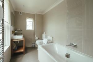a white bathroom with a tub and a toilet at Winemaker's Pub in Goudhurst +35 photos