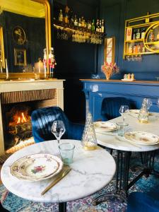 a dining room with two tables and a fireplace at L'Hôtel Particulier du 12 in Niort