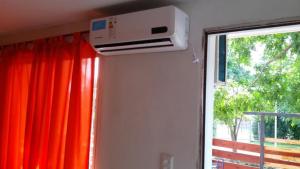 a air conditioner is on the wall next to a window at Cabañas El Paraiso in Villa Parque Siquiman