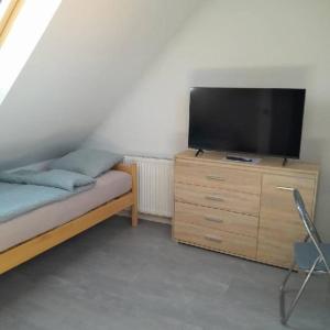 a bedroom with a tv on a wooden dresser at Noclegi Bielawa in Bielawa