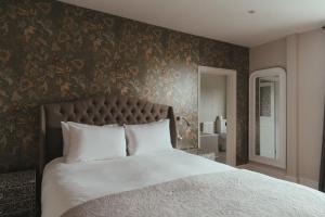 a bedroom with a large bed with a floral wallpaper at Winemaker's Pub in Goudhurst