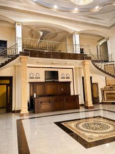 a large room with a staircase and a television in a building at Hayot Hotel Skazka in Qarshi