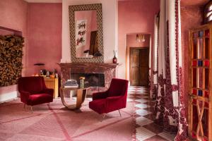 a living room with two chairs and a fireplace at El Fenn in Marrakesh
