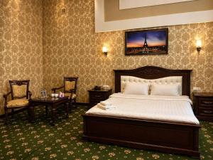 a hotel room with a bed and a table and chairs at Hayot Hotel Skazka in Qarshi +18 photos