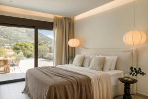 a bedroom with a large bed and a balcony at Kisterna Luxury Living in Makriótika