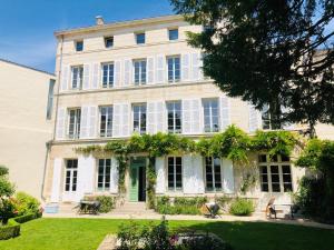 a large white house with a green door at L'Hôtel Particulier du 12 in Niort
