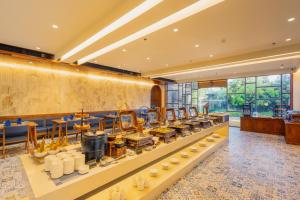 a buffet in a hotel lobby with a lot of food at The Forest Chapter by Sayaji Sasan Gir in Chitrod
