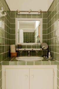 a green tiled bathroom with a sink and a mirror at Casa Ostara in Condorcet +92 photos