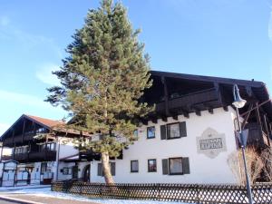 un pin devant un bâtiment blanc dans l'établissement Alpina Inzell 108 - Chiemgau, à Inzell