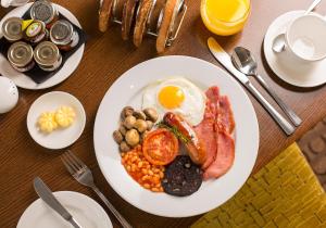 a plate of breakfast food with eggs bacon beans and mushrooms at Sandford Springs Hotel and Golf Club in Kingsclere