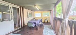 a porch with a table and chairs on a balcony at Bungalow-Mobilhome - Petit prix- Océan -Forêt -Camping 3 étoiles in Bias