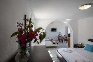 a living room with a vase of flowers on a table at Sandy Steps Beachfront Apartments in Malia