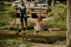 a man and a woman sitting on a swing at Vakantiehoeve Si-Es-An in Balkbrug