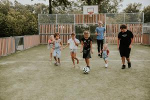 a group of children walking on a basketball court at Vakantiehoeve Si-Es-An in Balkbrug +3 photos