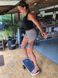 a woman standing on a skateboard in a store at Surf house langkawi in Pulau Tepur