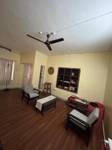 a living room with couches and a ceiling fan at Leos Inn in Pune