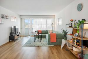 a living room with a green couch and a table at BASEKAMP Horizon I Luzern I Familie I Pilatus in Lucerne