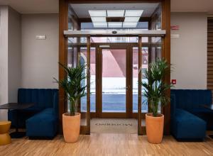 a lobby with two potted plants in front of a door at Hotel Moderno in Bari