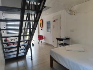 a room with a staircase and a bed and a table at Rays of Bliss in Mananthavady