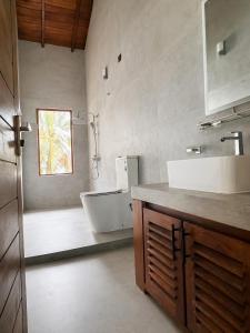 a bathroom with a tub and a sink and a bath tub at CocoBaru - Private Beachfront Entire Villa in Marawila +5 photos