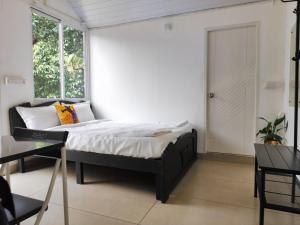 a bedroom with a bed in a room with a window at Rays of Bliss in Mananthavady