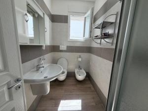 a small bathroom with a sink and a toilet at Casa Ca 'Luci in Marina San Gregorio +16 photos