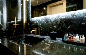 a black bathroom with a sink and a mirror at The Grand Blue Boutique Hotel in Missolonghi