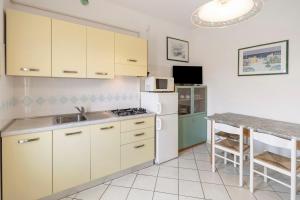 a kitchen with white cabinets and a white refrigerator at Residenza Stella X in Bibione