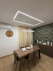 a dining room with a wooden table and chairs at Elled-home in Misterbianco