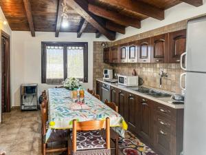 a kitchen with a table with chairs and a refrigerator at Casa Gli Allori in Iglesias
