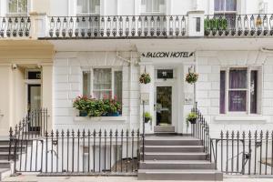 a white building with a staircase in front of it at Falcon Hotel in London